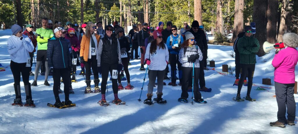 Participants toe the start line for the 5K Snowshoe Race at Camp Richardson, Lake Tahoe, 2024
